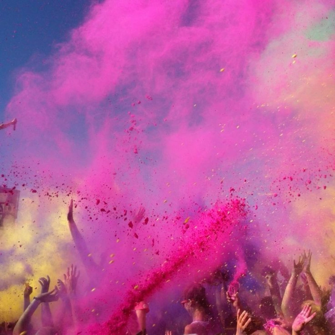 Pink gulal powder cloud during a vibrant Holi festival celebration